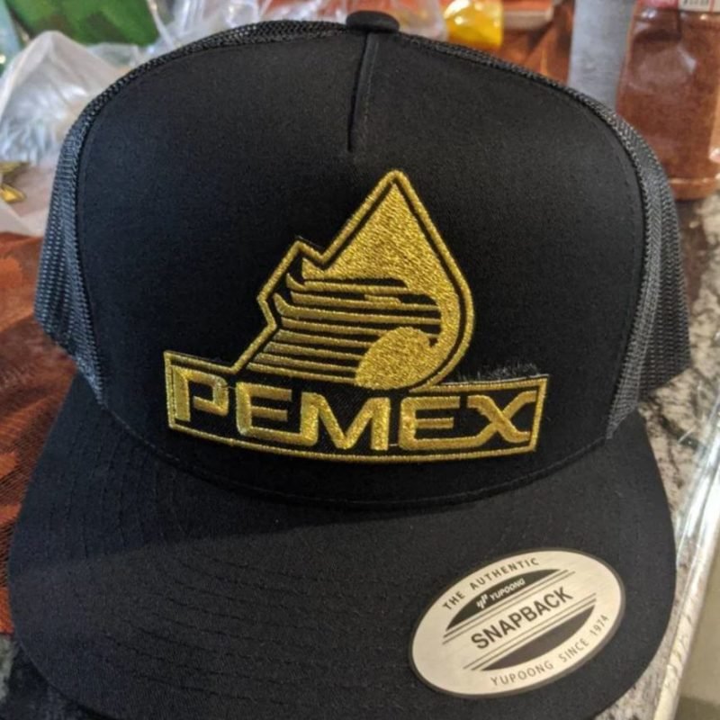 Black Pemex trucker hat with gold embroidered eagle logo and snapback bill sticker.